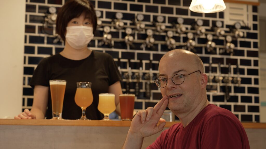 Jörg in der Sakaduki-Brauerei (2022), mit der Besitzerin im Hintergrund.